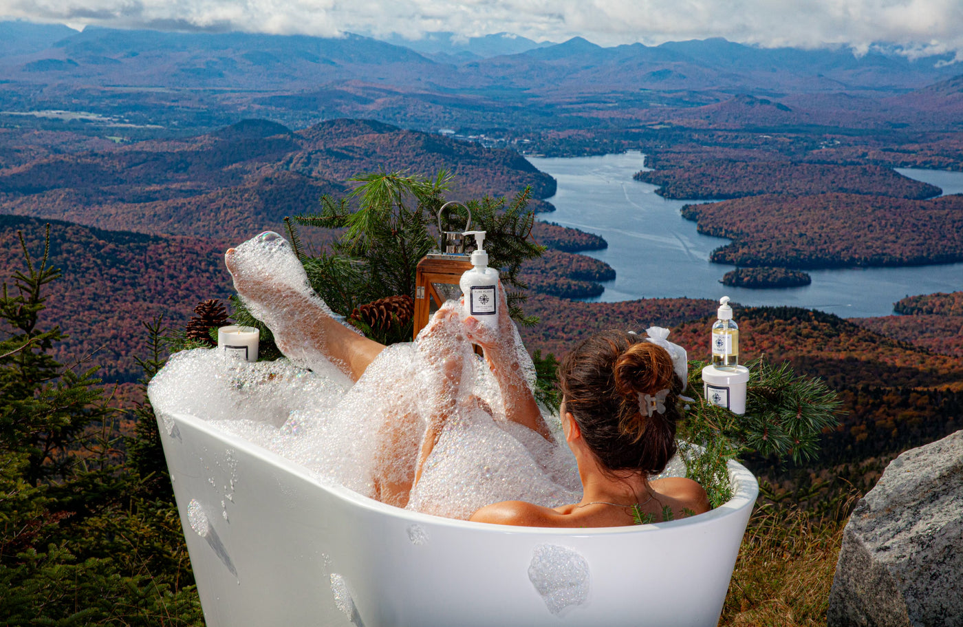 Woman in bubble bath outside on top of mountain using pure placid products